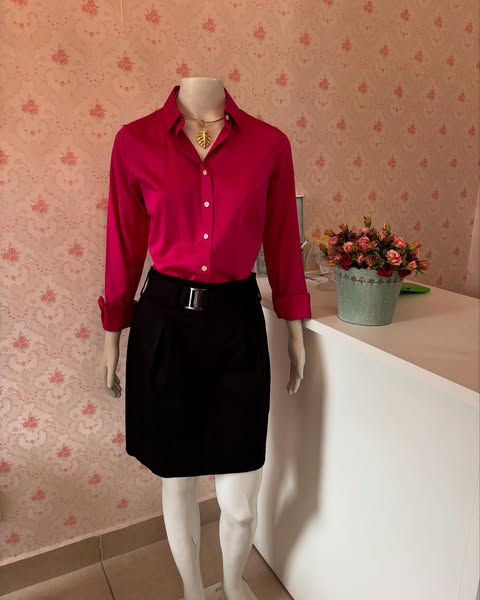 Look profissional com camisa magenta e saia preta em manequim